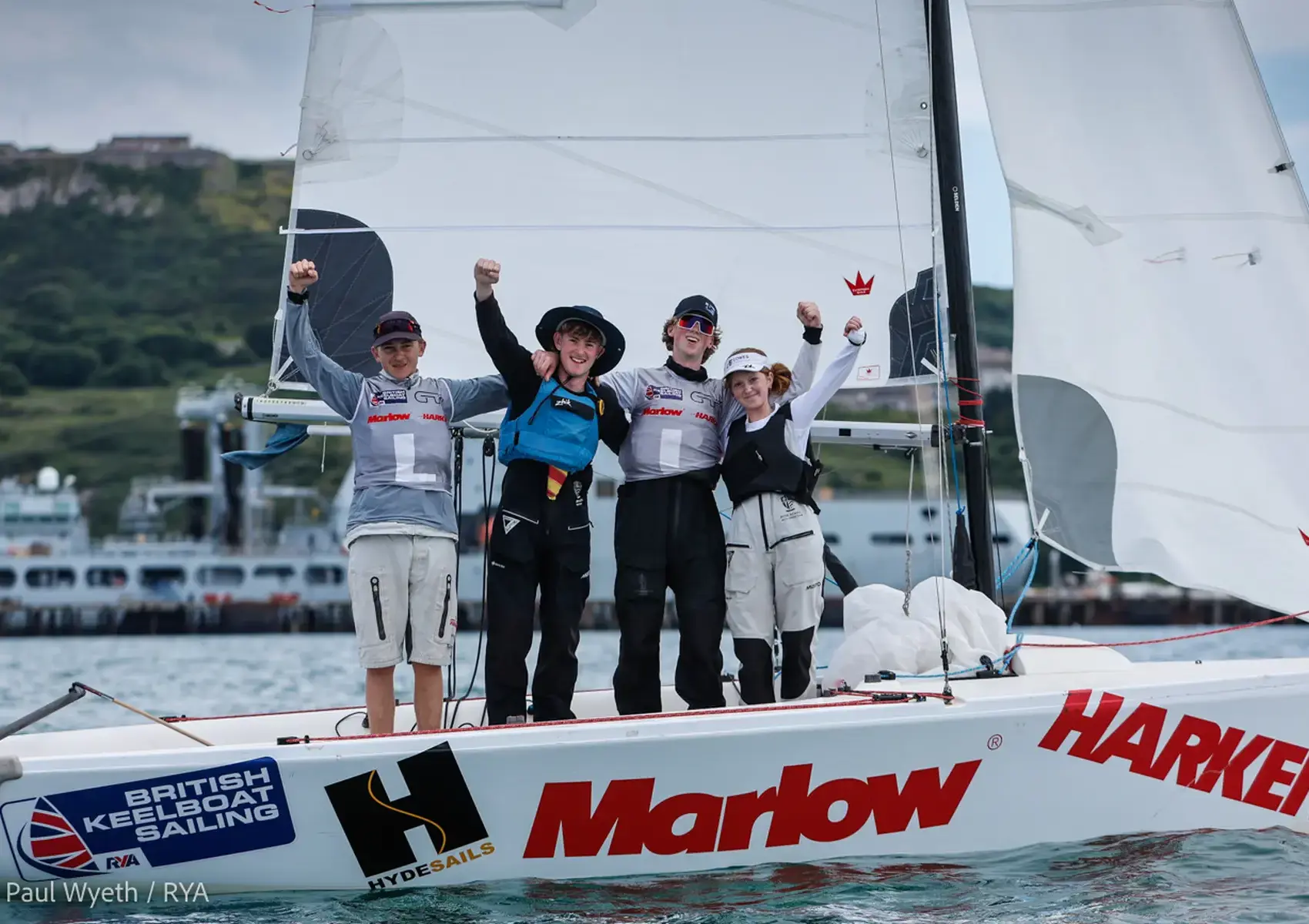 Four students on a sailing boat after winning the national Youth Match Racing championships in WeymouthContent Landscape Image