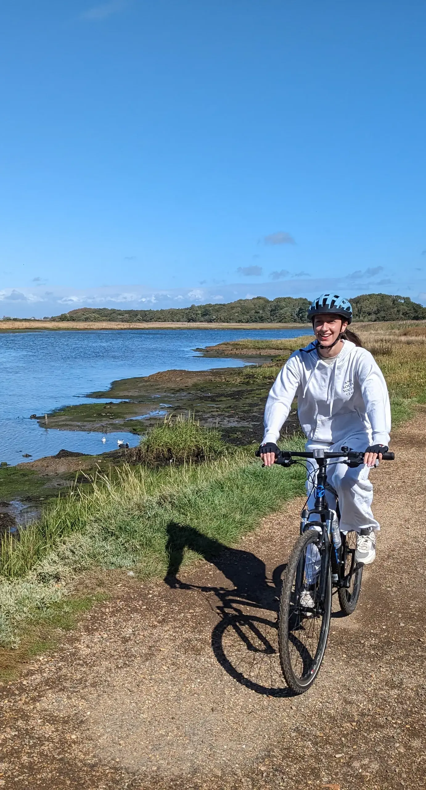 Girl on a bike near a riverPortrait image - Content