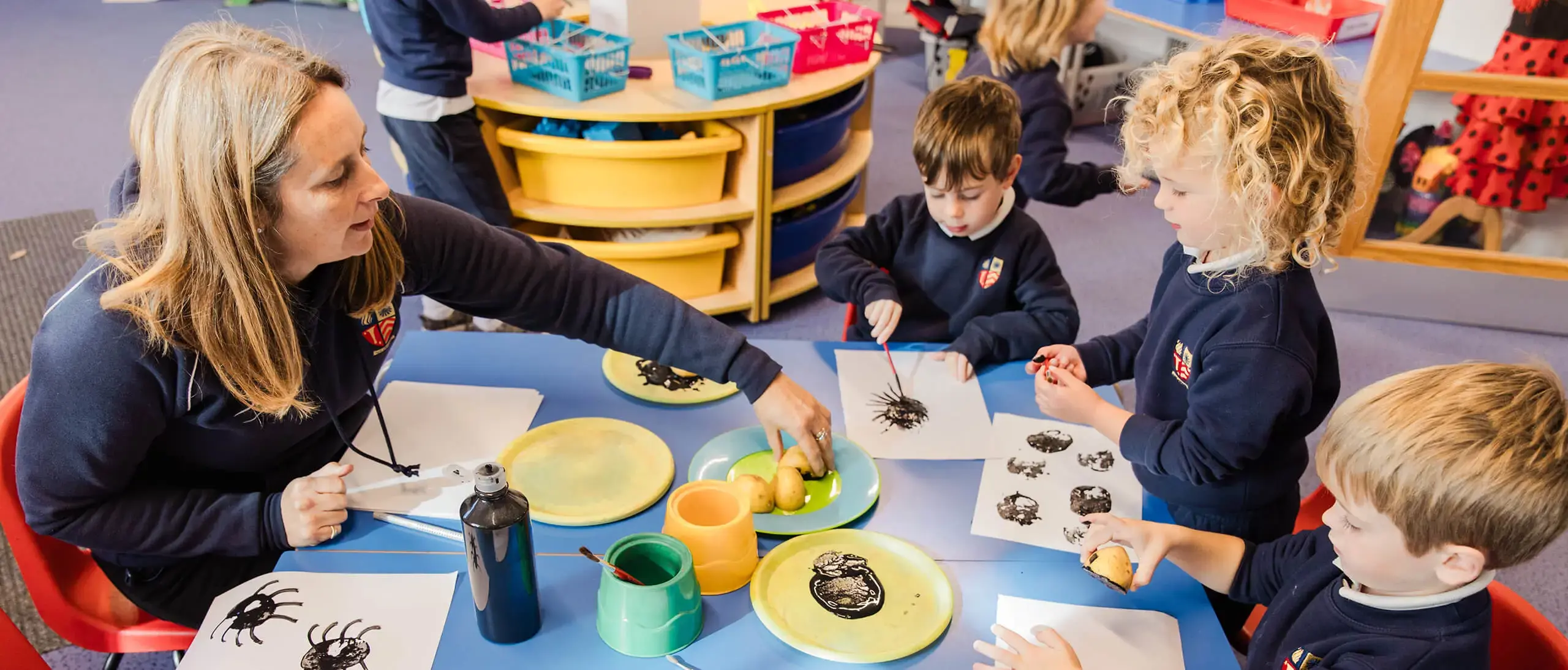 Ryde School Pre-Prep pupils and teacher creating stamps with potatoes